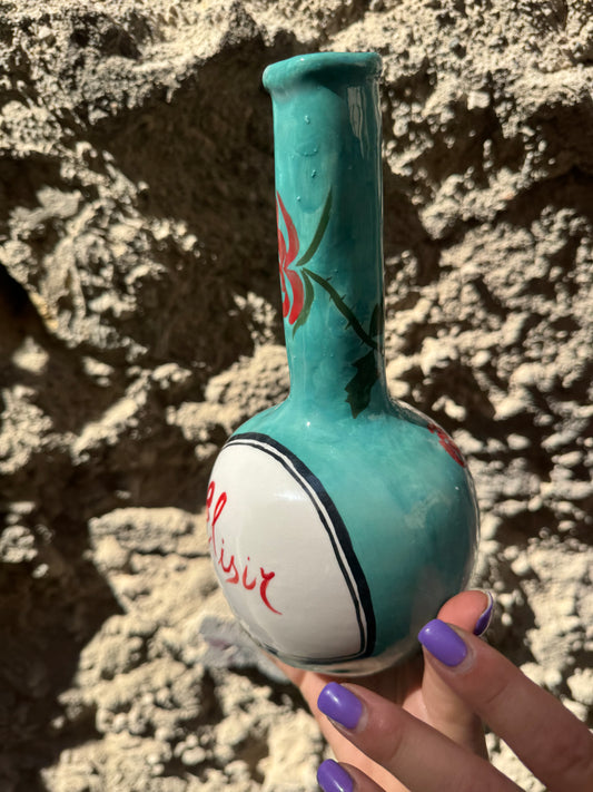 Bottiglia di Elisir D'Amore Oilloc2 con etichetta dettagliata e contenuto liquido visibile in un flacone di vetro.
