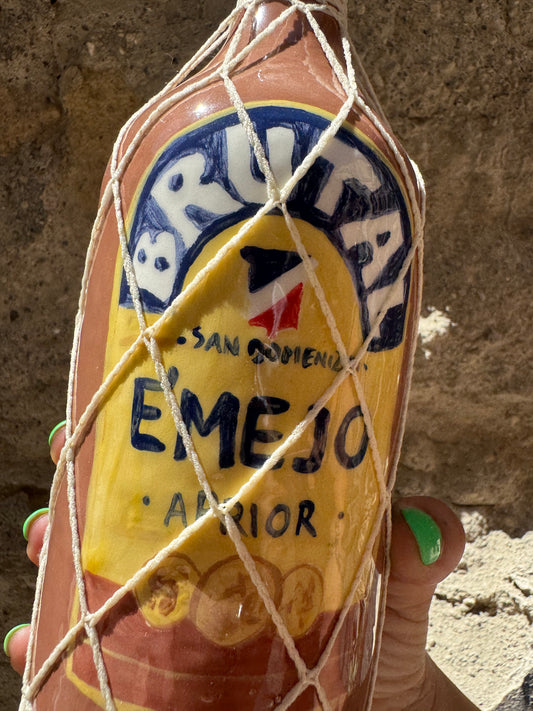 Bottiglia di olio brutale Ron Oilloc2 con etichetta nera e dettagli dorati, vista frontale sul tavolo.