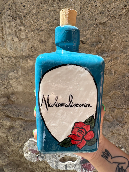 Alcolicomalinconica Oilloc2, bottiglia di alcolico con etichetta nera, vista frontale su sfondo neutro.