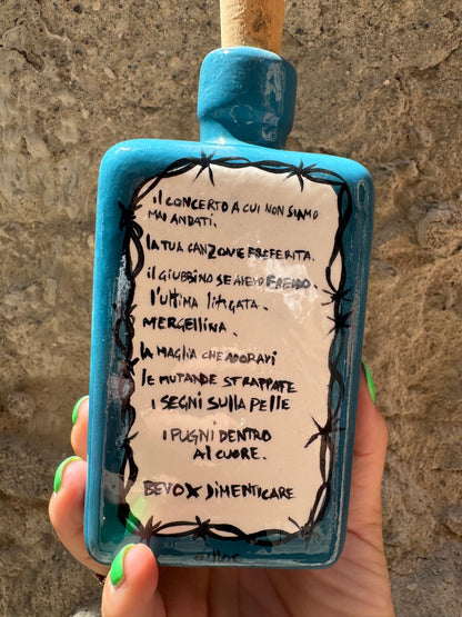Bicchiere di alcolico malconico di Oilloc2 con dettaglio di bottiglia e bicchiere su sfondo neutro.