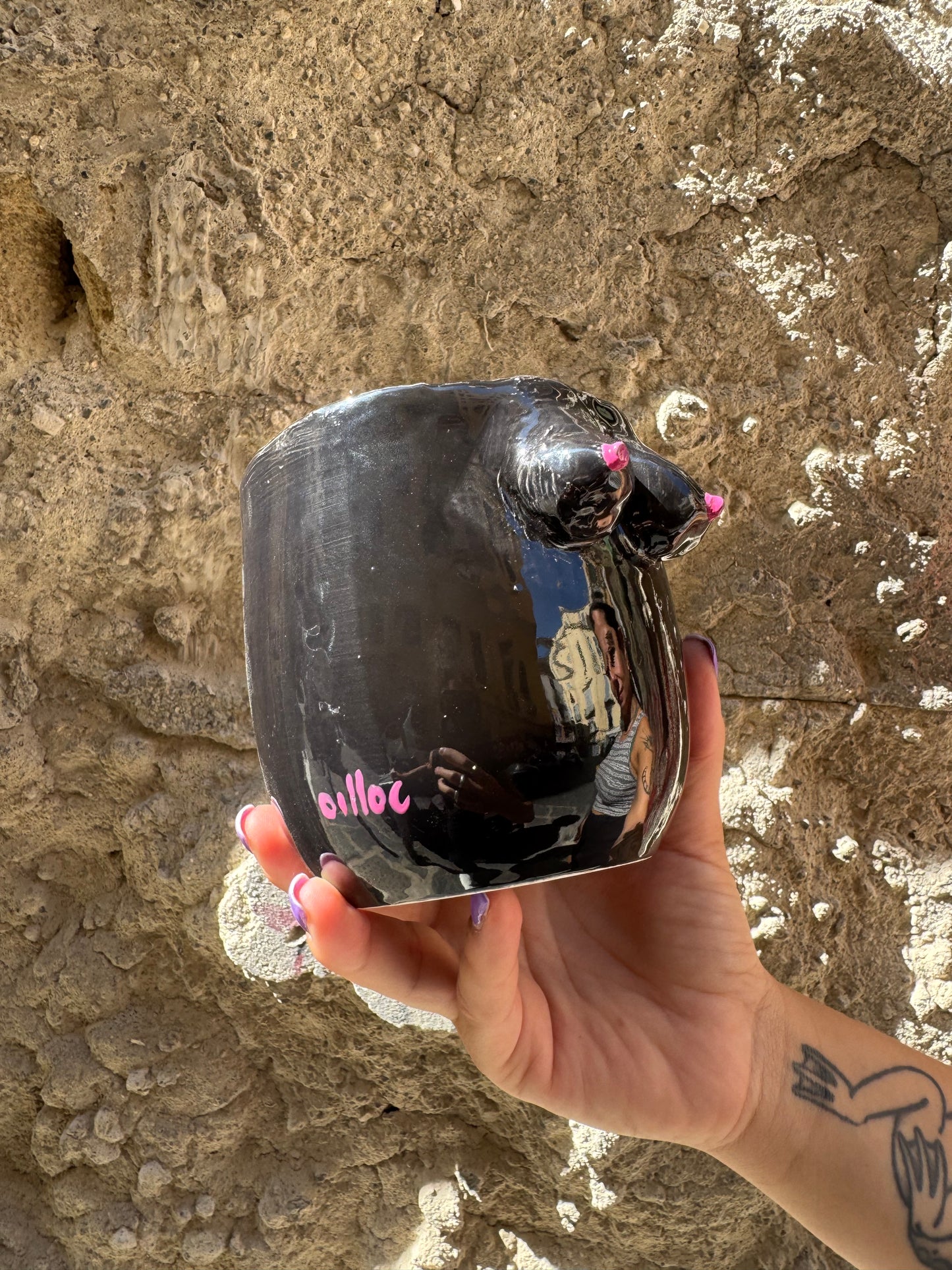 Vaso nero a forma di seni femminili, design originale di Oilloc2, decorativo e moderno, visibile in primo piano.